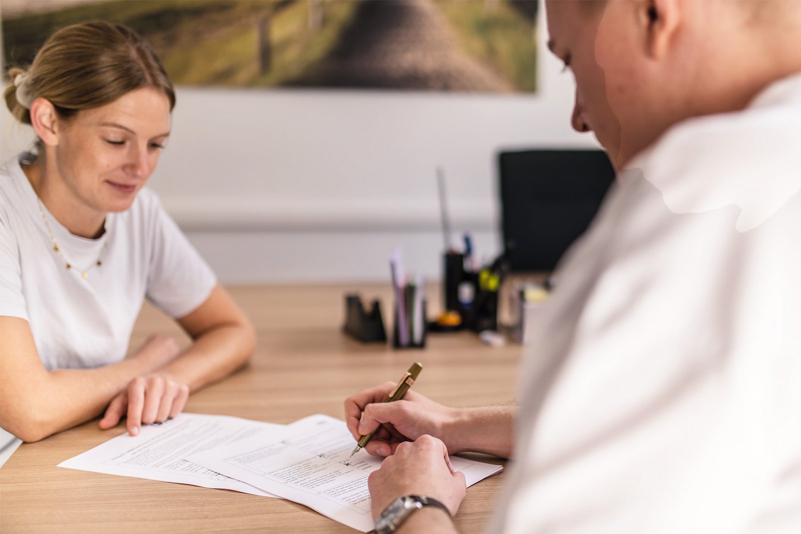 Zwei Personen füllen in einem Beratungsgespräch Formulare aus