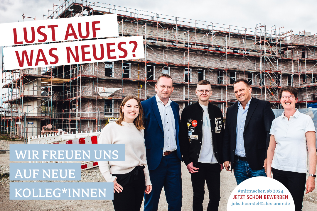 Fünf Menschen stehen vor einem Neubau mit Gerüst